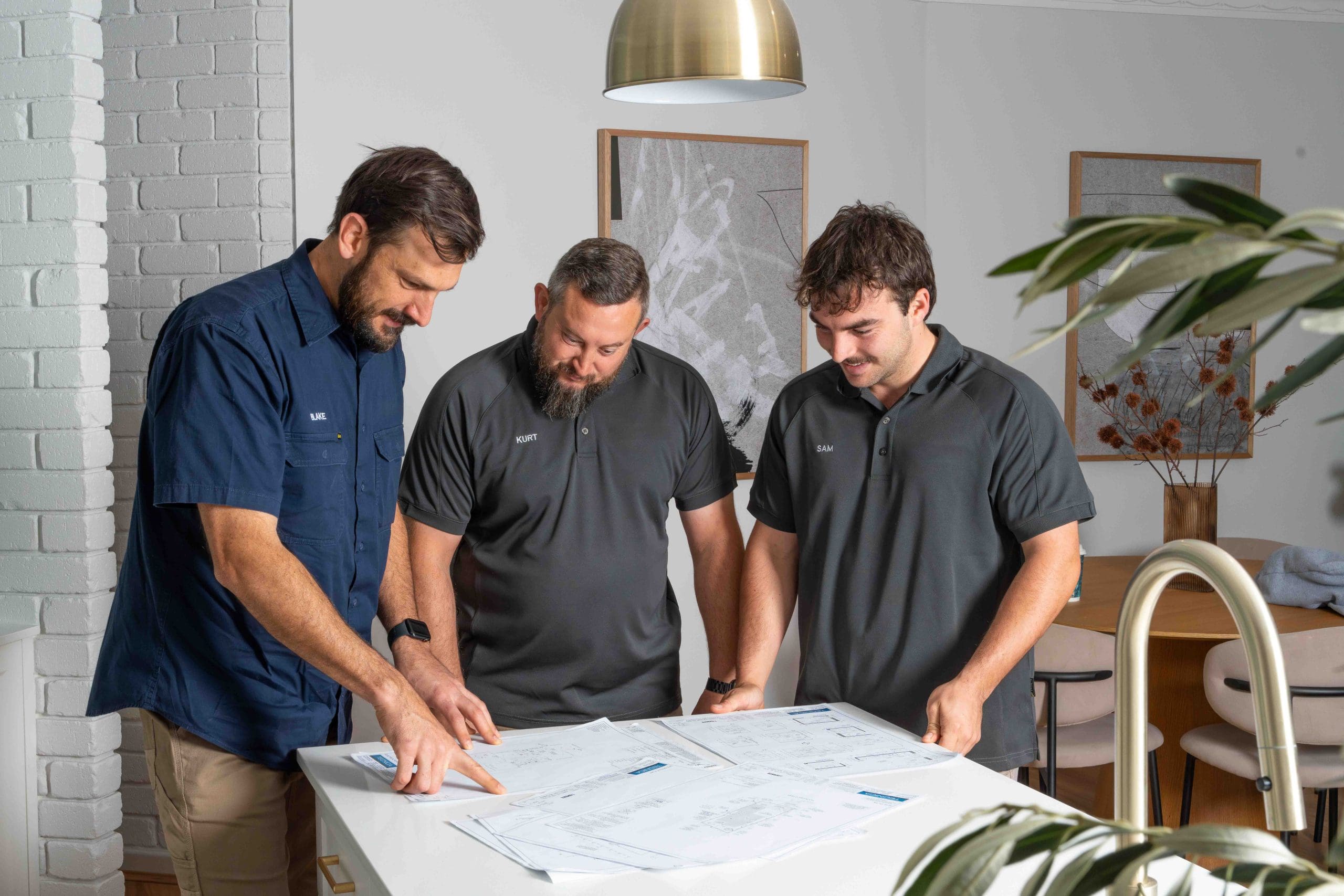 Electricians in Gwelup reviewing plans at a modern office table.