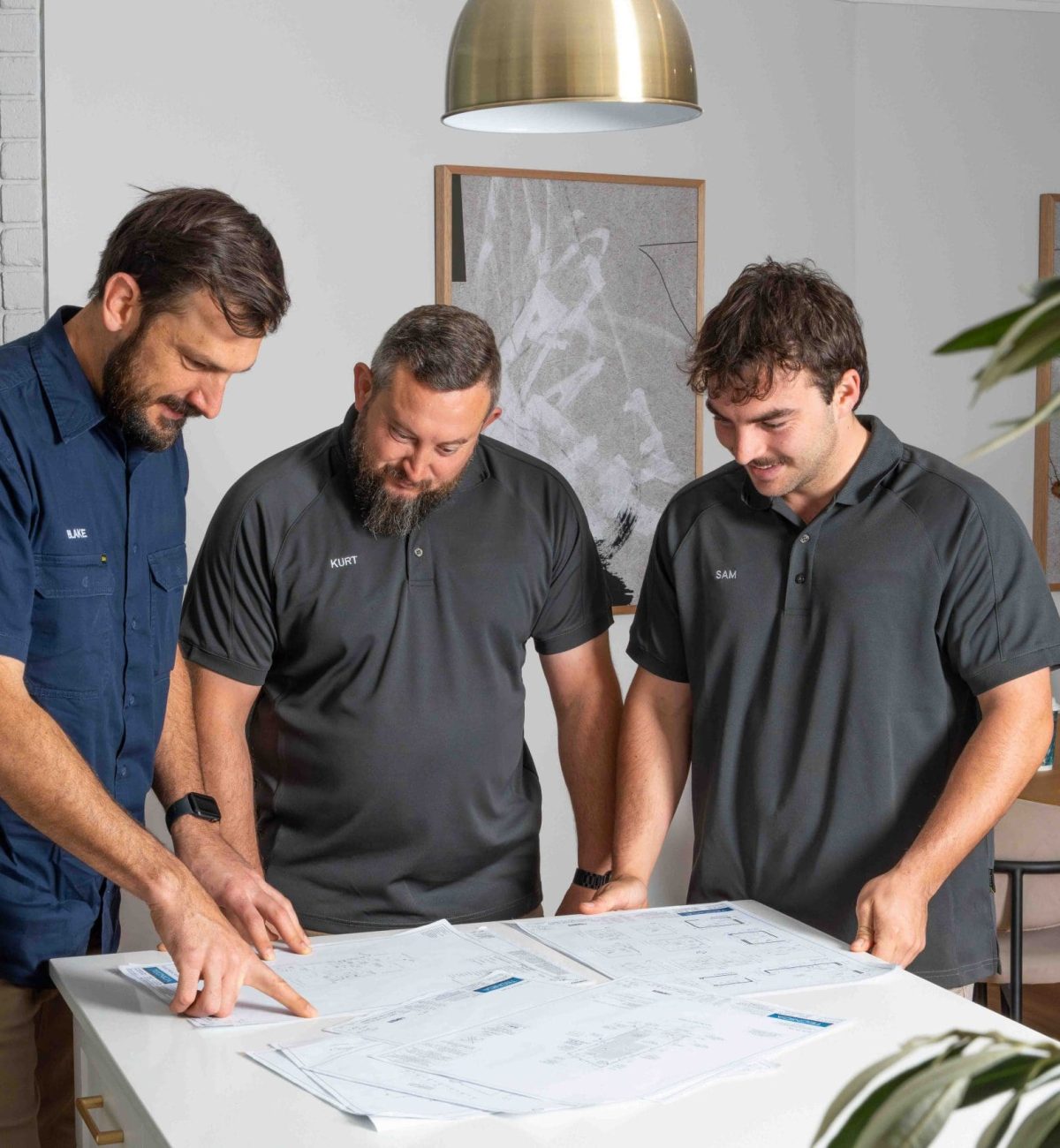 Electricians in Gwelup reviewing plans at a modern office table.